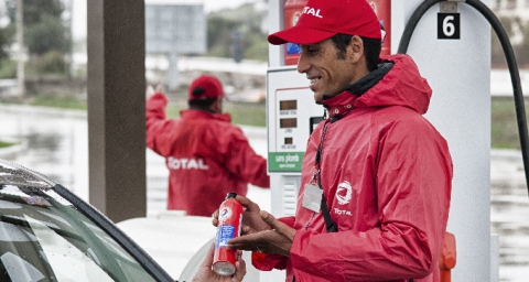 Gas station attendant selling a product to a customer. Tanger, Maroc