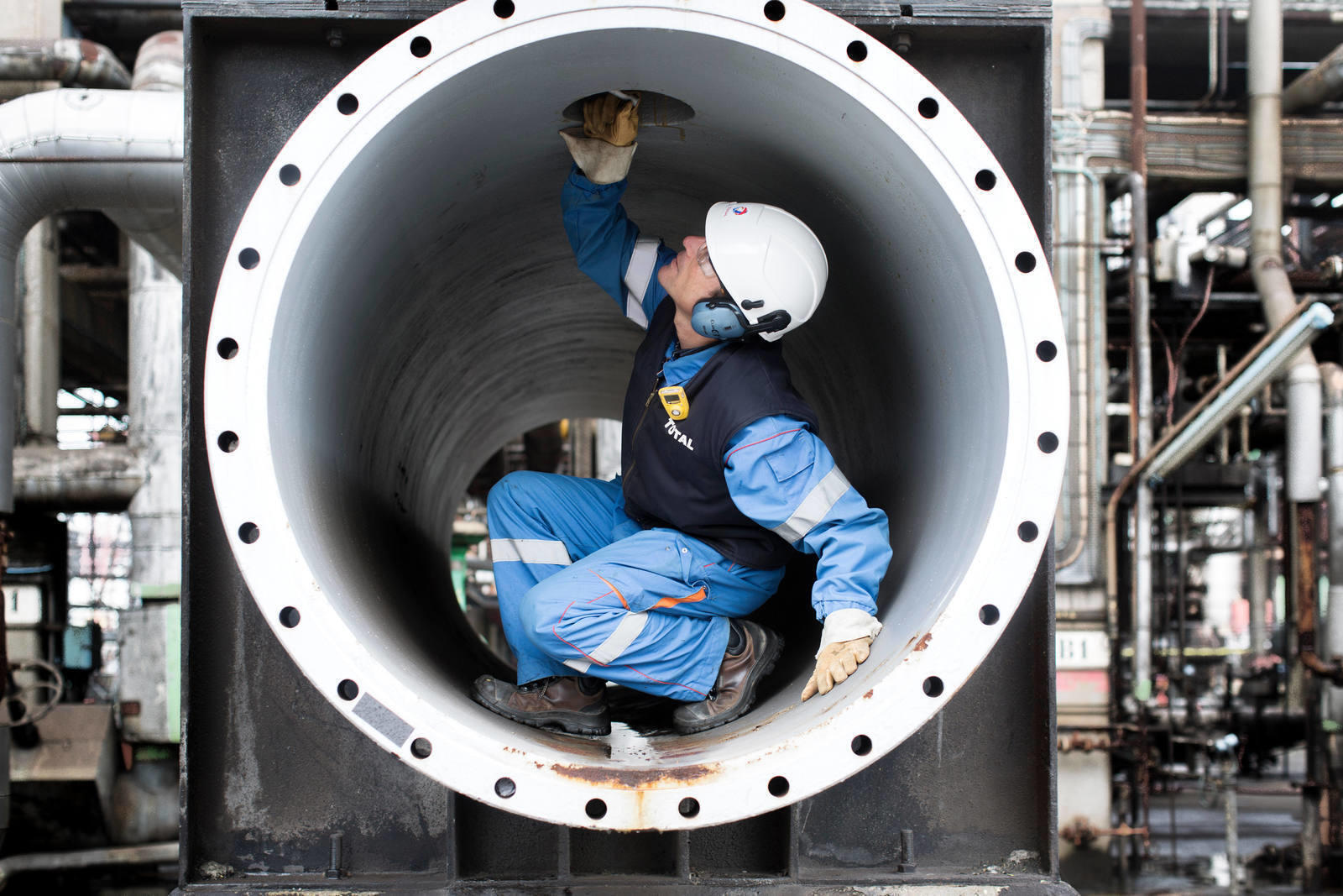 individual inside a pipe with personal protective equipment
