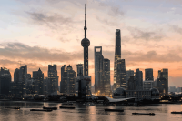 China, Shanghai skyline at dawn, showing the Huangpu river with passing cargo ships and Pudong skyline