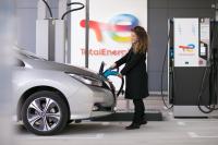 Femme chargeant son véhicule à la station électrique
