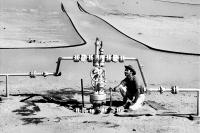 Compagnie de recherche et d'exploitation de pétrole au Sahara (CREPS) - Centrale de détente dans le Sahara - Relevé de pression effectué par un homme accroupi. Elf aquitaine