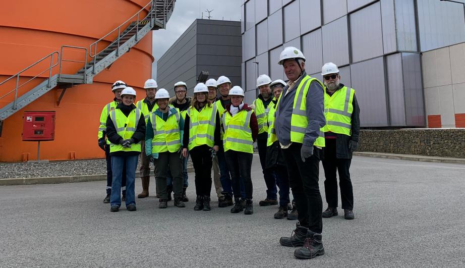 © TotalEnergies Personnes regroupées devant un site industriel - voir description détaillée ci-après