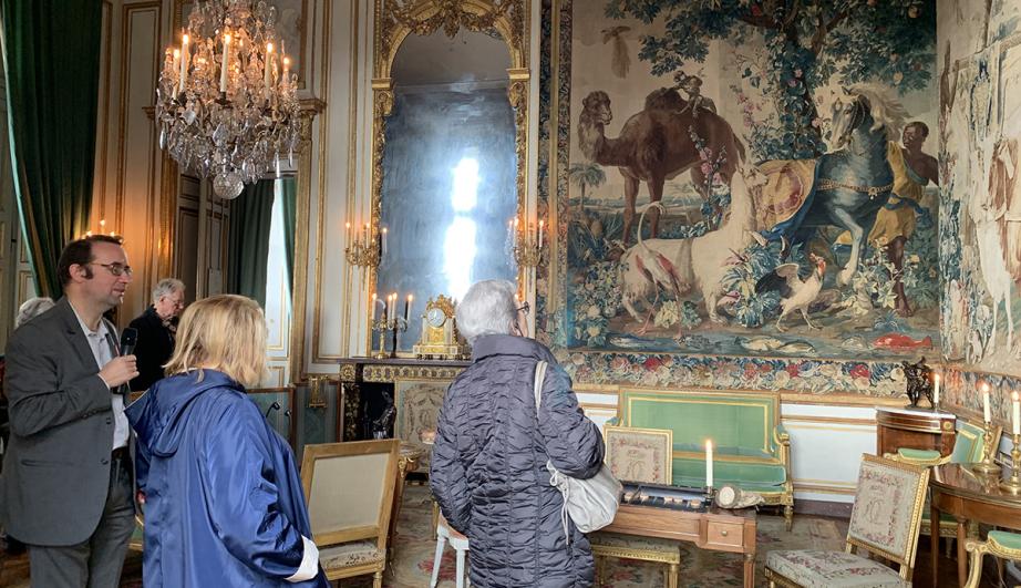 © TotalEnergies groupe de visiteurs observant un tableau dans une salle - voir description détaillée ci-après