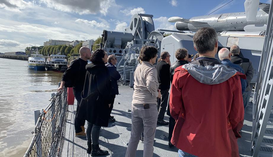 © TotalEnergies visiteurs sur un bateau - voir description détaillée ci-après